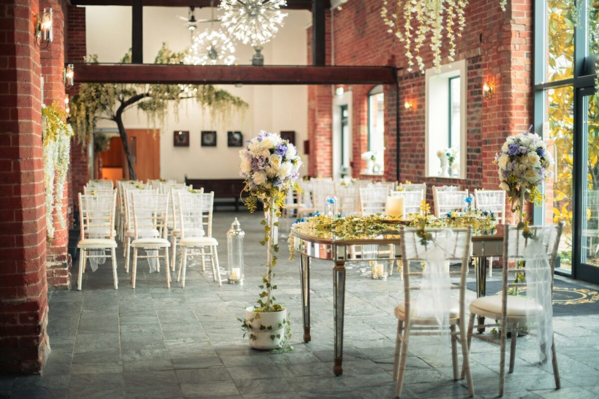 Elegant indoor event space with white chairs and floral decorations